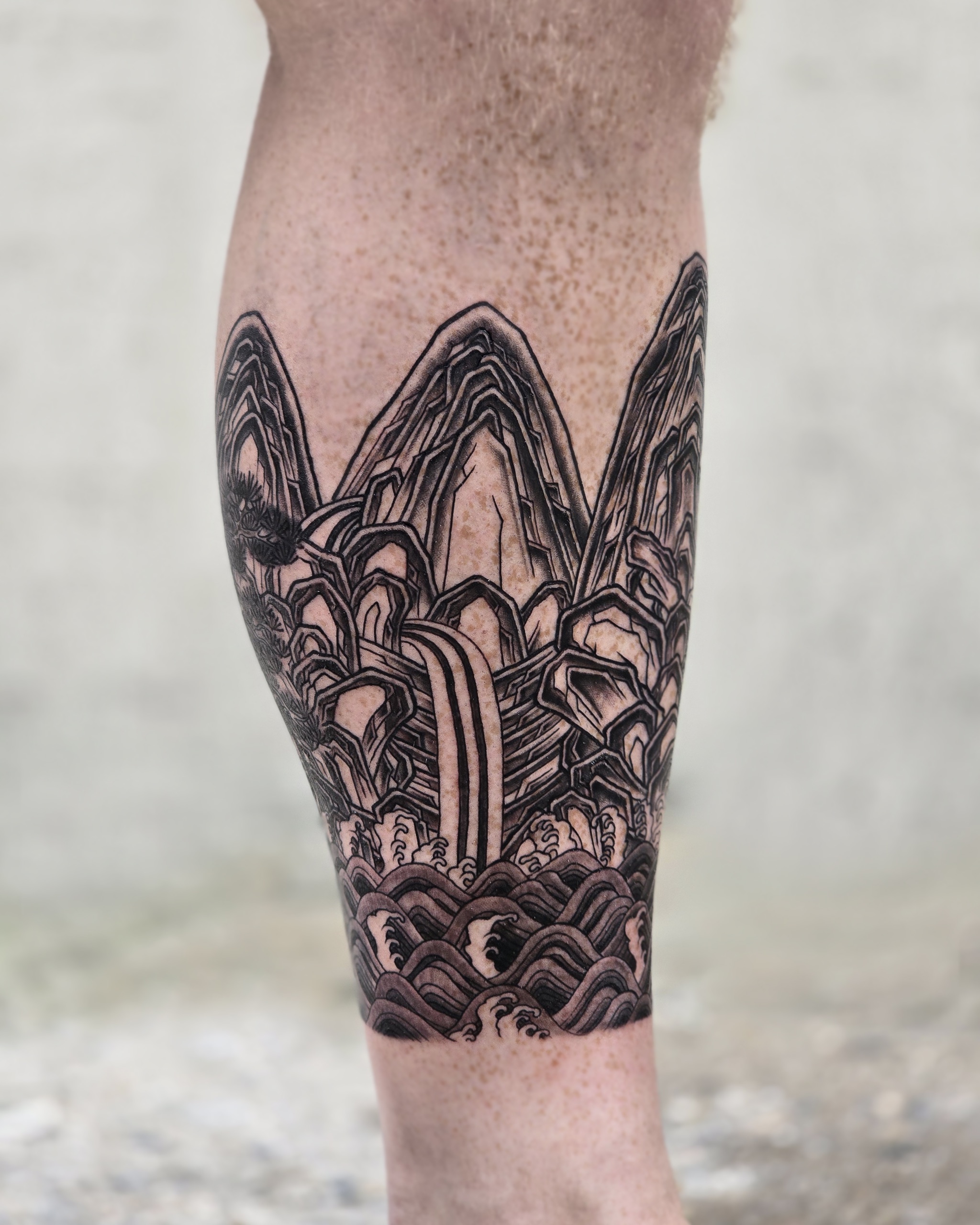 Five Peaks Landscape — black-and-grey calf tattoo