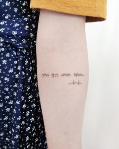 Small handwritten Korean lettering tattoo with a heartbeat line on the forearm, Seoul